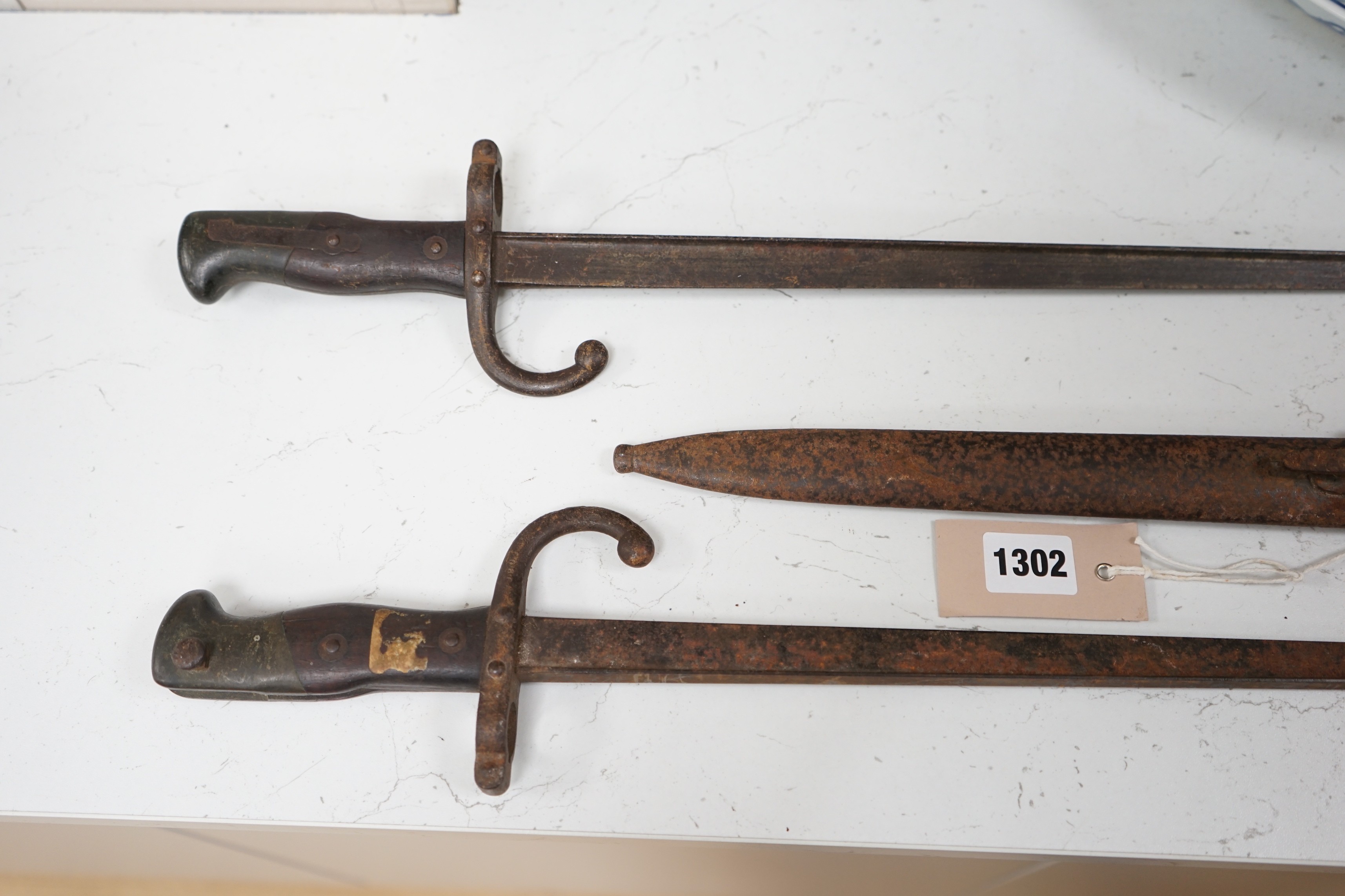 A WWI German bayonet and sheath and two other bayonets